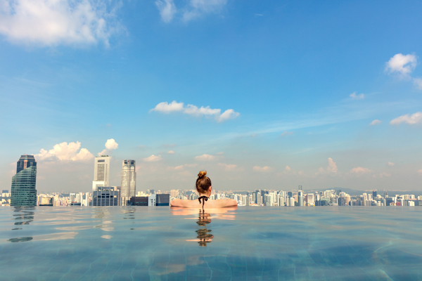 Turista na piscina infinita do Marina Bay Singapore Skypark olhando para a cidade em Cingapura